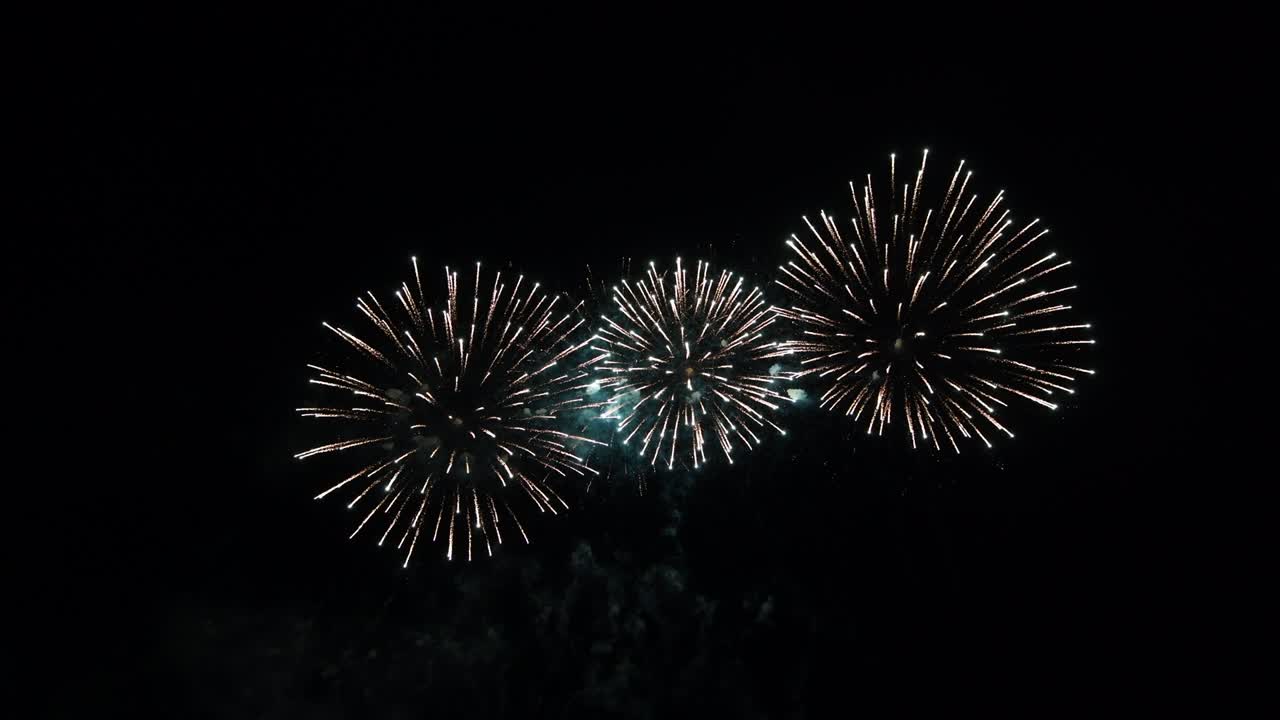 Loop seamless of real fireworks with abstract blur bokeh lights in night sky. Glowing fireworks festival. New year's eve 2022 fireworks celebration