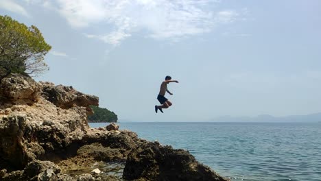 Clip-En-Cámara-Lenta-De-Un-Hombre-Saltando-Del-Acantilado-Al-Agua-En-Croacia