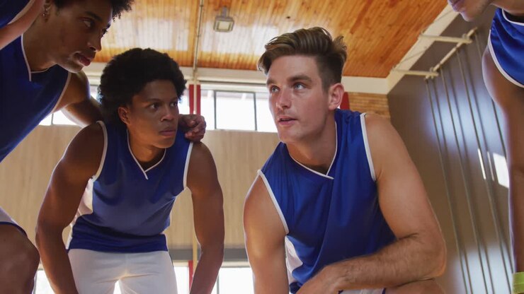 vielfältige männliche basketballmannschaft in huddle diskutiert spieltaktik