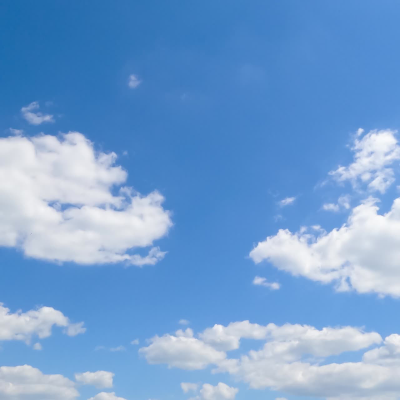 Fluffy little clouds in the blue skyline. Terrific timelapse of the cloudscape moving in the summer sky