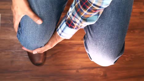 hombre sosteniendo la rodilla lesionada