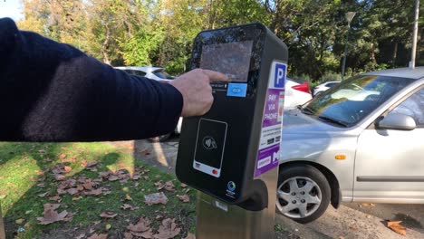 persona que utiliza el servicio de pago por tap en el parquímetro