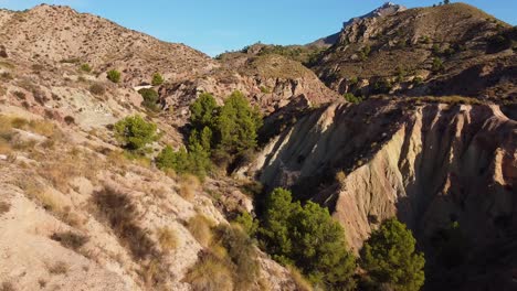 Rugged-topography-of-cliffs-and-canyons-in-the-harsh-landscape-of-Monnegre-in-the-Alicante-Province-of-Eastern-Spain---aerial-pull-back-flyover