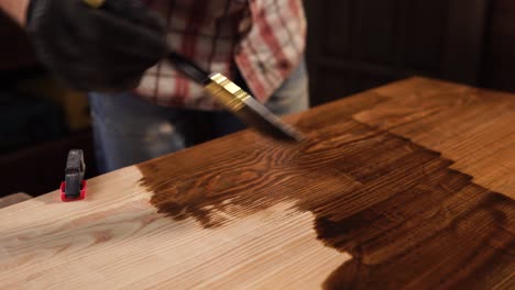 applying wood stain to a wooden table top