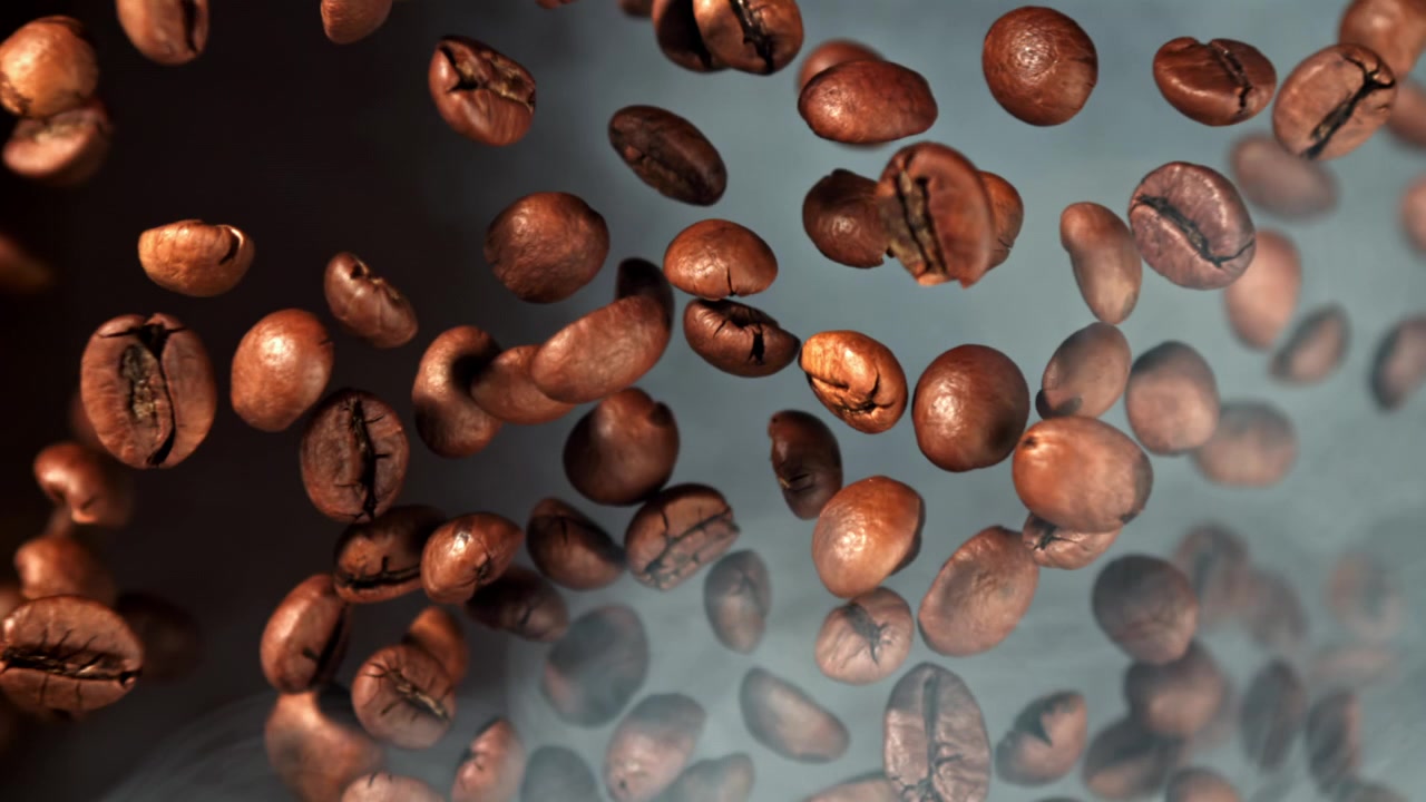 Chicchi di caffè appena tostati che cadono al rallentatore tra il fumo