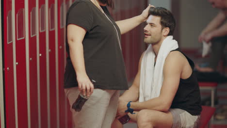 funny female stylist tidying man hair in checking room.