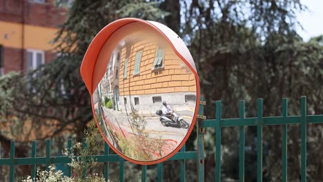 traffic mirror reflecting a building and surroundings