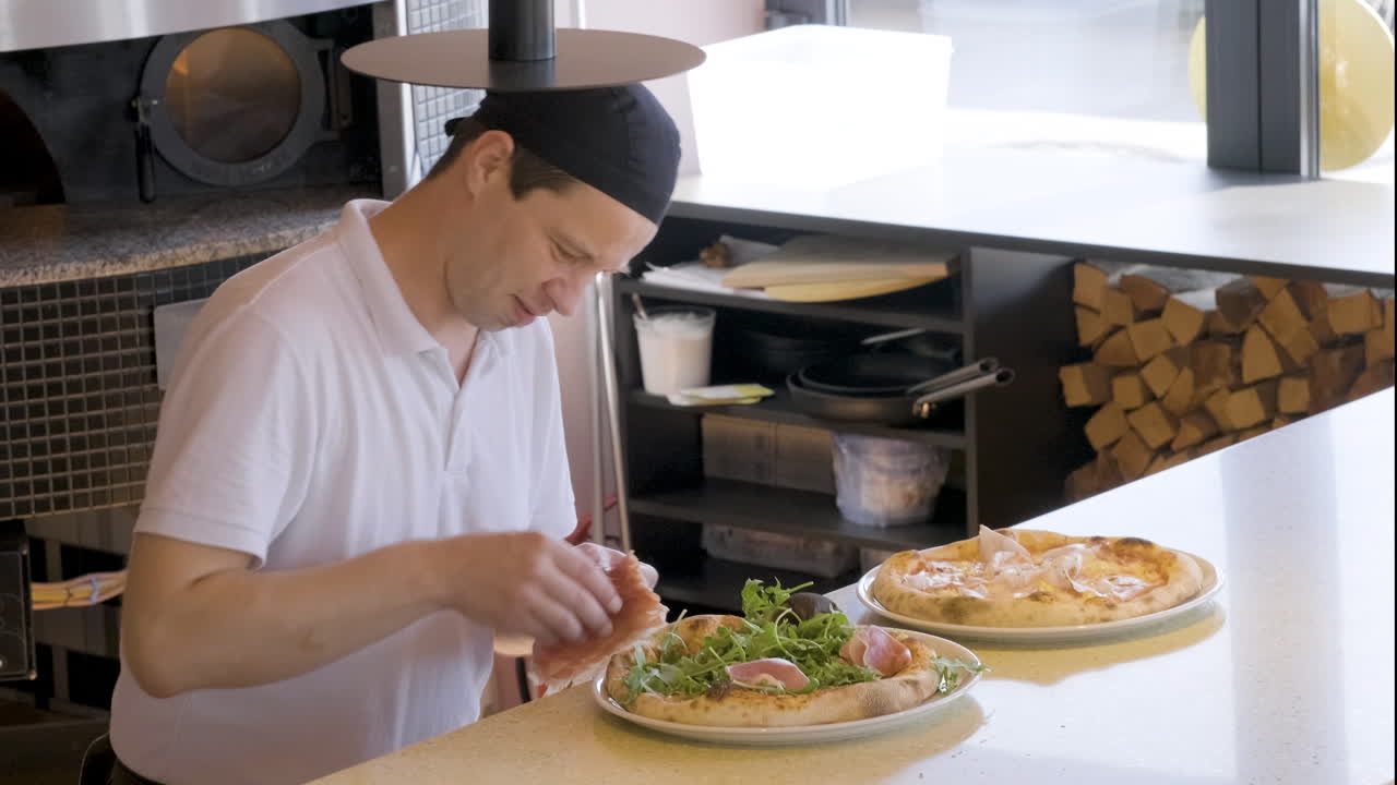 chef agregando jamón a la pizza en el restaurante