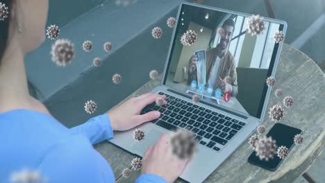 animación de células de covid 19 sobre hombre de negocios con máscara facial en una llamada de video portátil