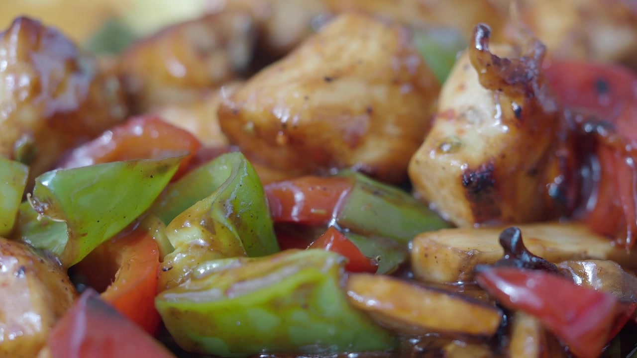 Primo piano di pollo cotto con peperoni e funghi