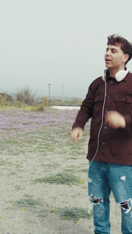 music giving the rhythm to a man dancing on the shore with headphones