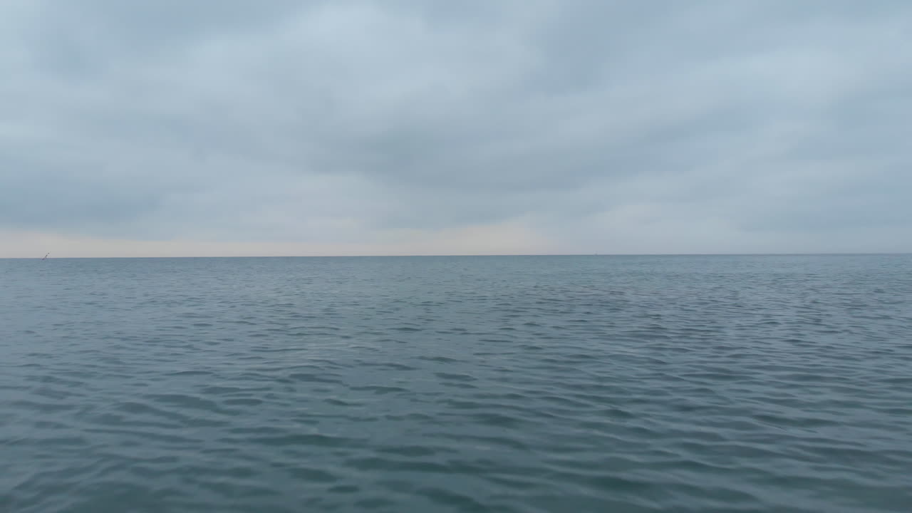 무인 항공기는 잔잔한 바다의 고요한 유리 표면 위에 낮은 고도에서 비행