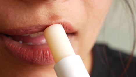 woman applying lip balm close-up