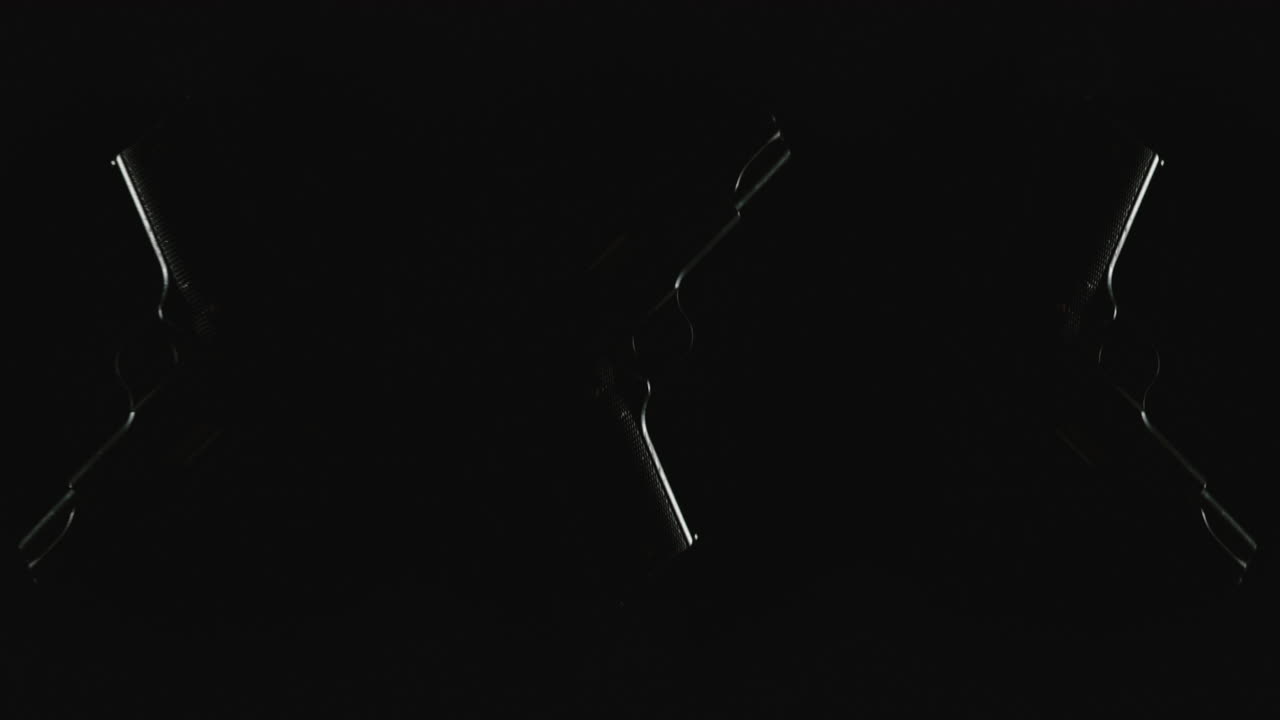 Three pistols on the dark background and in blinking lights are falling in slowmotion