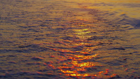 Primer-Plano-Olas-Del-Mar-Salpicando-Arena-Playa-En-Cámara-Lenta-Noche-Naranja-Atardecer