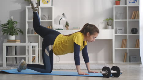 chica adolescente atlética está entrenando en casa sola levantando la pierna hacia arriba tensando los músculos en el hogar fitness y estilo de vida saludable de pie en la alfombra deportiva en la habitación