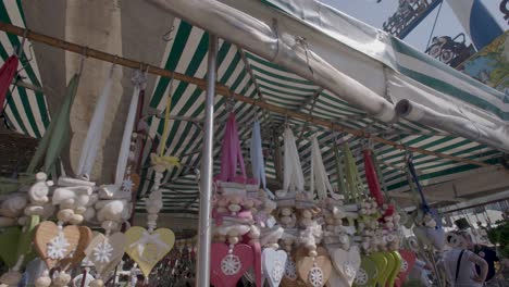 Panning-shot-of-traditional-Bavarian-festivities-on-a-sunny-day,-showing-a-tent-and-traditional-pole