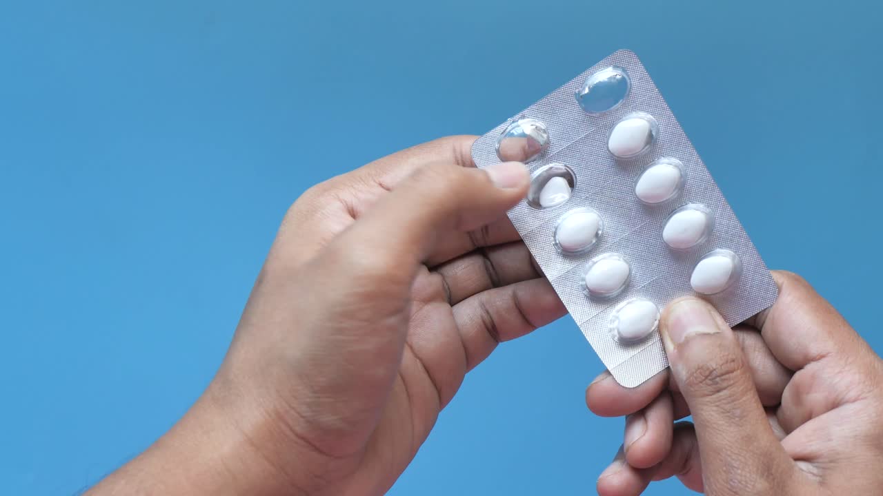 Hands holding a blister pack of pills