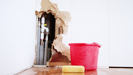 Damaged-Wall-With-Leaking-Water-Pipe-And-Bucket