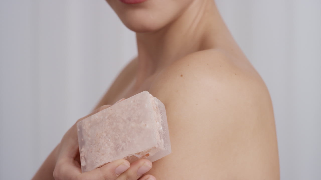 ritratto ravvicinato di una splendida giovane donna che tocca delicatamente la pelle nuda con sapone di lusso per la cura della pelle che accarezza una carnagione morbida bella donna caucasica che gode di un'esfoliazione sensuale