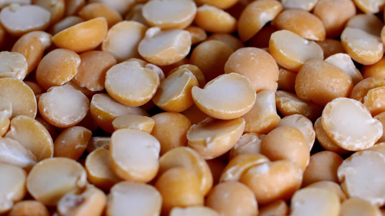 건조한 갈라진 노란 콩 어리가 회전판에 천천히 회전합니다.