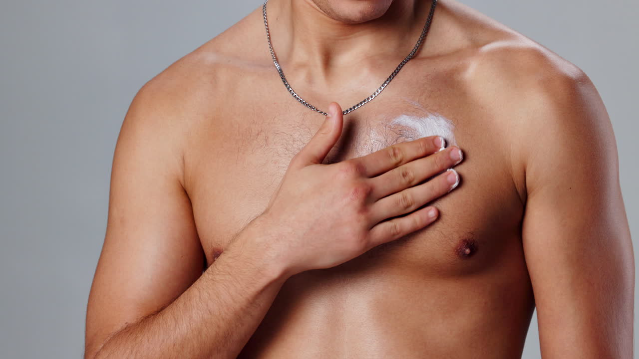 Man applying moisturizer on chest