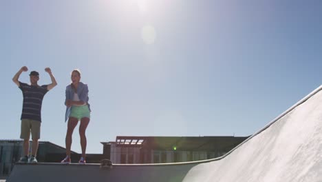 Kaukasische-Frau-Und-Mann-Jubeln-Ihrem-Skateboard-Freund-An-Einem-Sonnigen-Tag-Zu