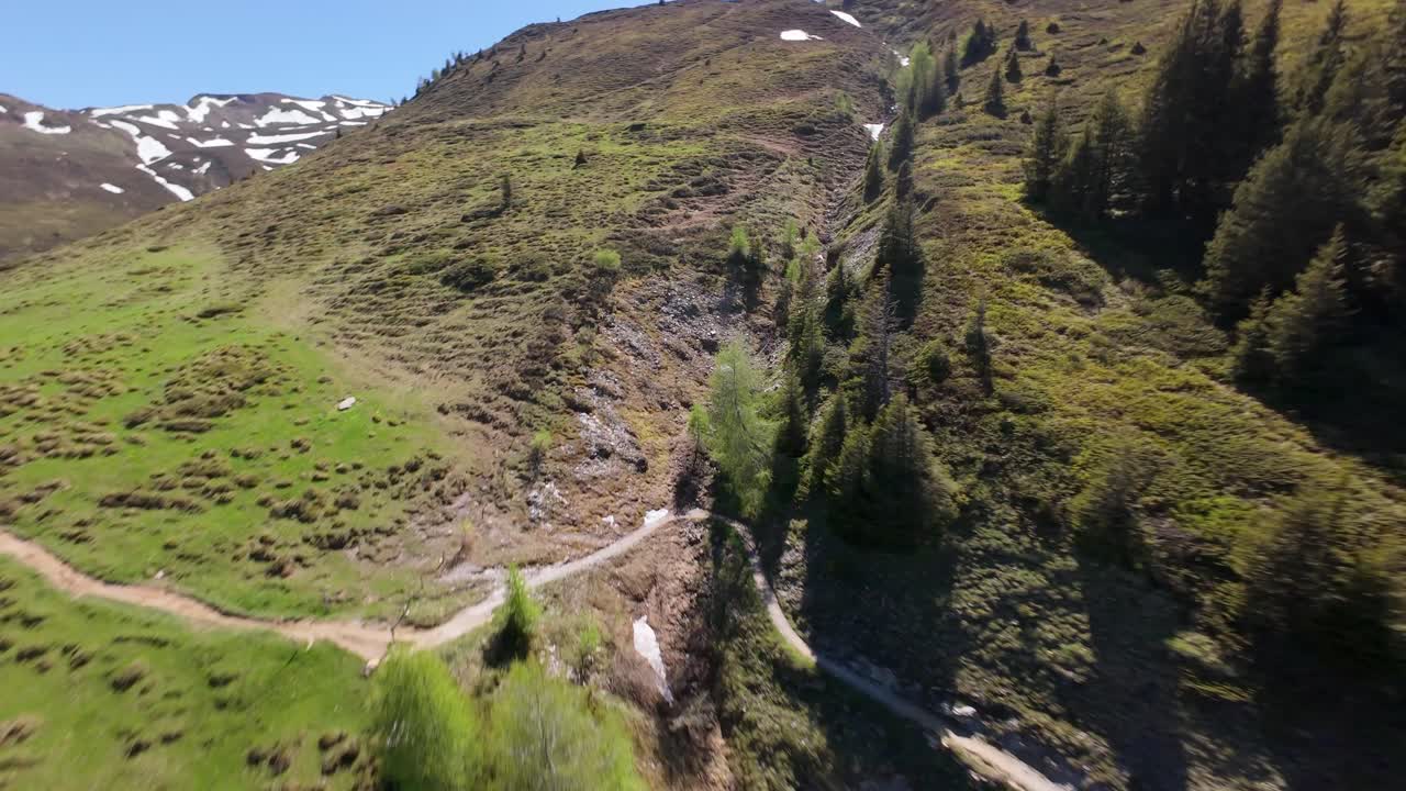 Spectacular fpv speed flight uphill green and rocky alps mountains in Switzerland. Sunny day whit blue sky in summer.