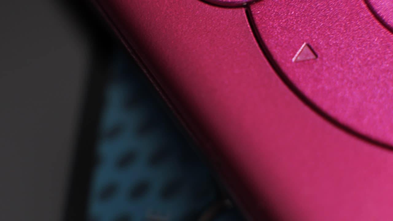 Macro close up of pink digital music player controls with play and pause icons rotating
