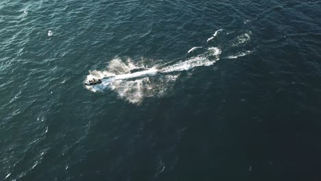 Jet-Ski-Moto-Acuática-Personal-Navegando-En-El-Agua-Del-Lago-Azul-En-Un-Día-Soleado,-Vista-Aérea-De-Drones