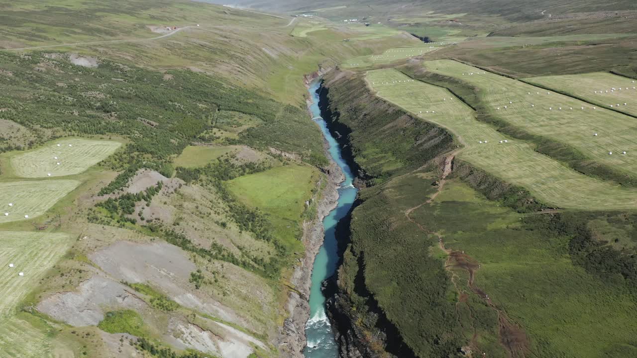 islandia río azul en el cañón con campos de cultivo verdes, studlagil, antena
