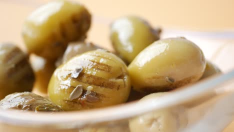 close-up of preserved green olives in a glass bowl