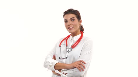 Young-female-doctor-walking-in,-smiling-friendly,-crossing-arms-and-looking-at-camera.-Portrait-of-young-medical-professional-with-stethoscope-and-lab-coat-isolated-on-white-background