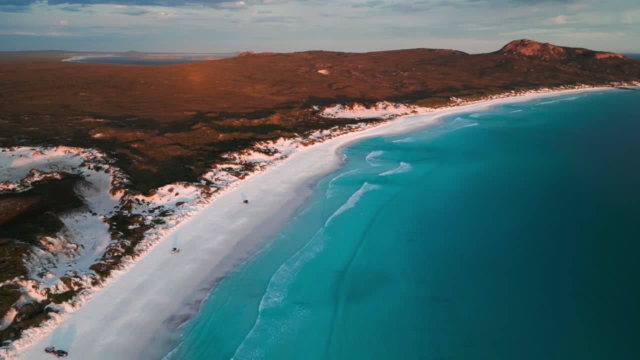 drone disparado sobre lucky bay al atardecer en el parque nacional de cabo legrand con 4wd en la playa, australia occidental