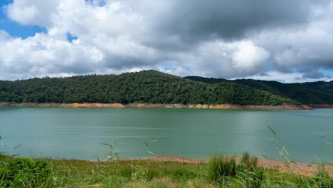 Zeitraffer-See-Calima-Mit-Wolken,-Die-Neben-Bergen-Ziehen,-Bewölkter-Tag