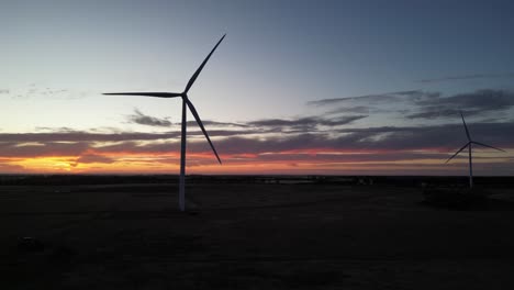 rotating wind turbines in field during golden hour in australia