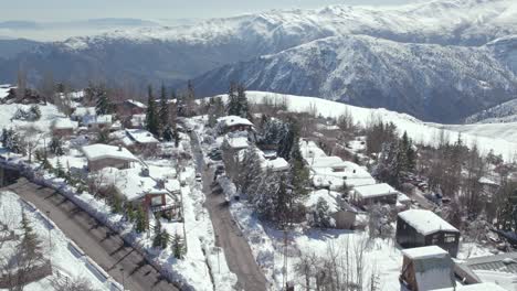 flyover the snow-filled mountain village of farellones with mountains in the background on a sunny day in chile