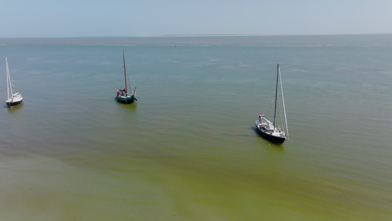 On a sunny day in the Netherlands, a group of boats are anchored in the North Sea