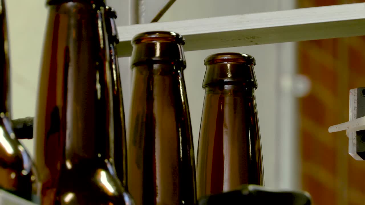 Close-up of Beer Bottles on a Conveyor Belt in a Brewery