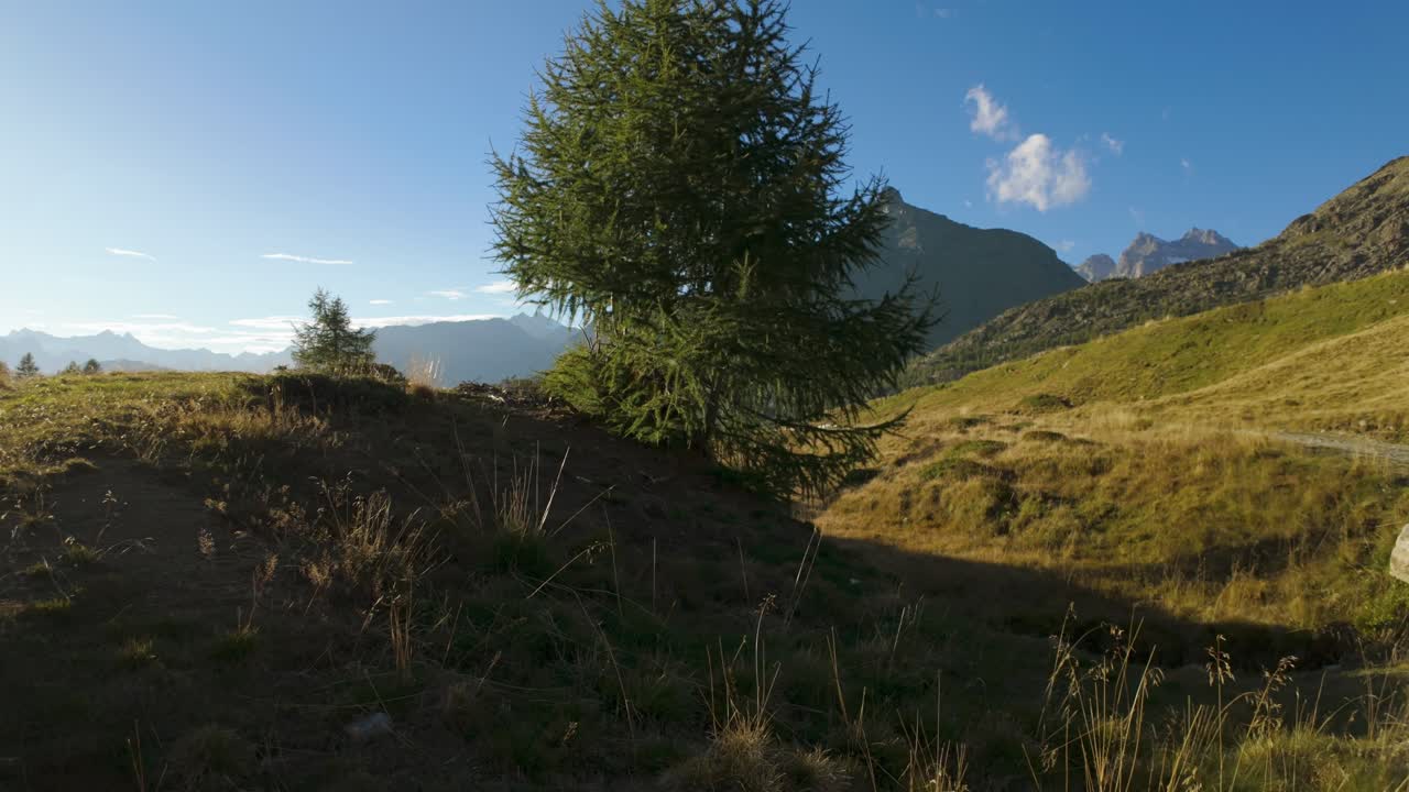 paisaje alpino italiano con picos de montañas, pequeños arroyos y colinas cubiertas de hierba