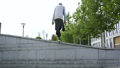 top view of the man with one leg on crutches doing a flip in the street.