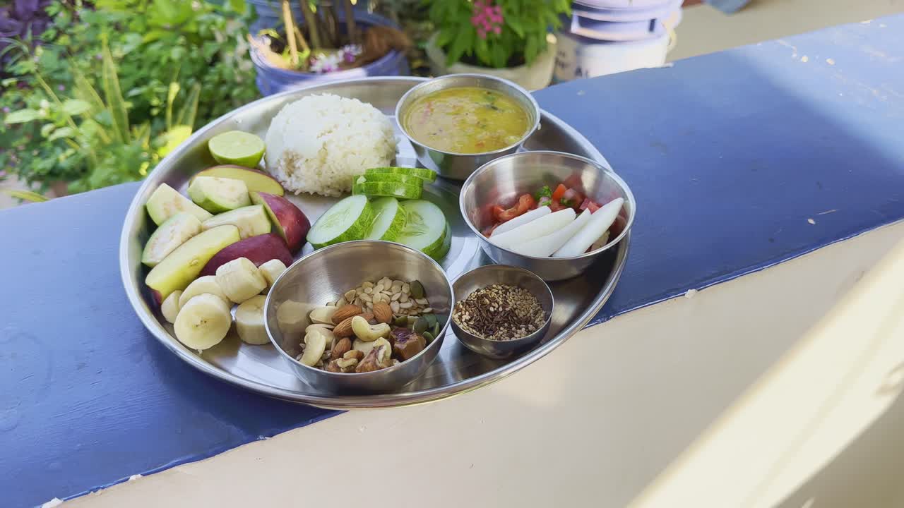 A wholesome and nutritious Indian thali featuring rice, dal, fresh fruits, nuts, seeds, and raw vegetables — a perfect balance of taste and health served in a simple, traditional style