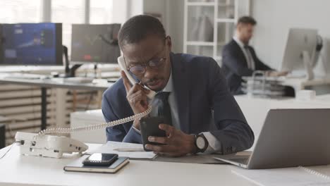 busy african american broker cooperating with investor on phone