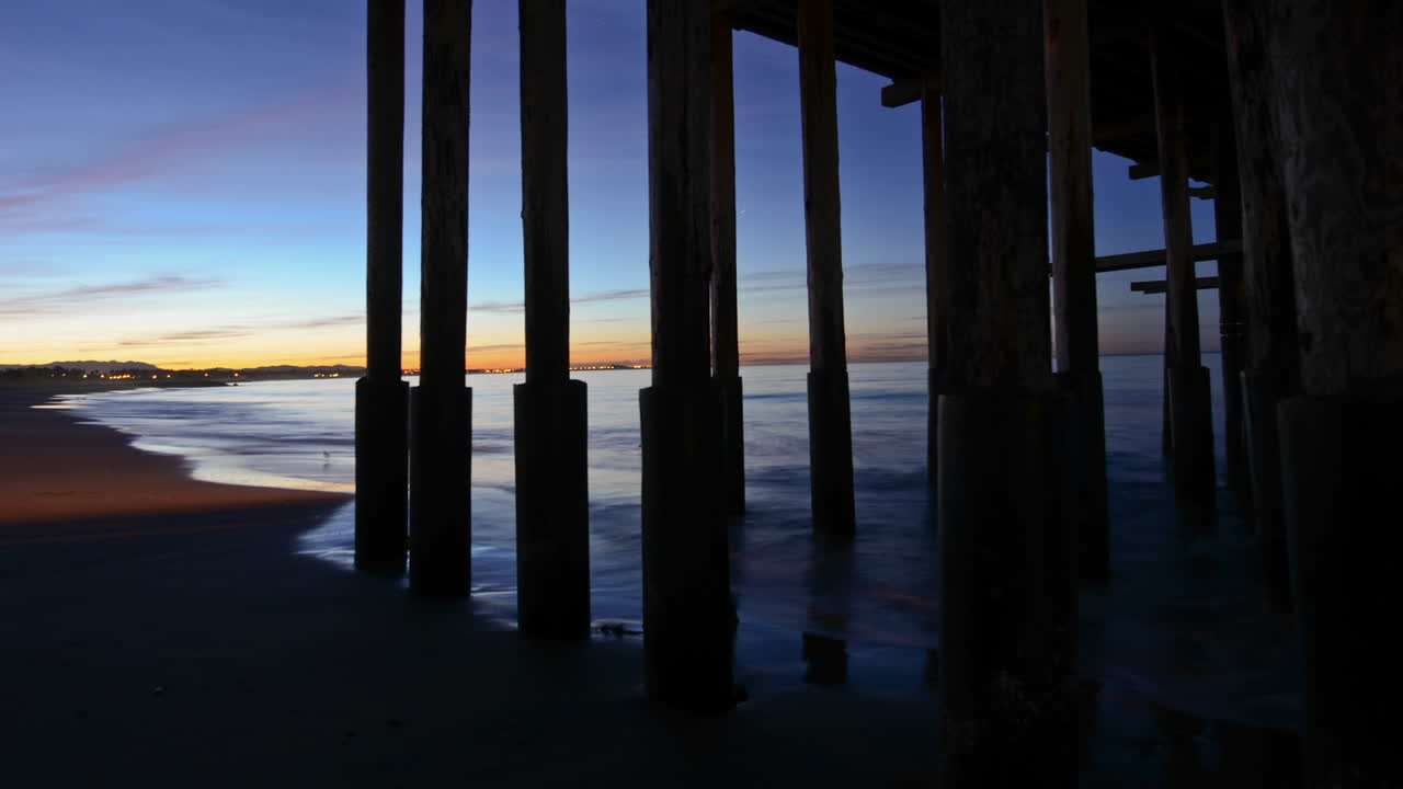 lapso de tiempo de la ola rompiendo bajo el muelle de san buenaventura al amanecer en ventura california