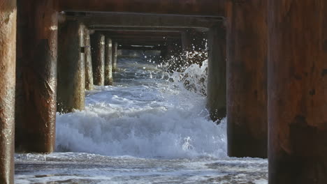 waves crashing under a pier