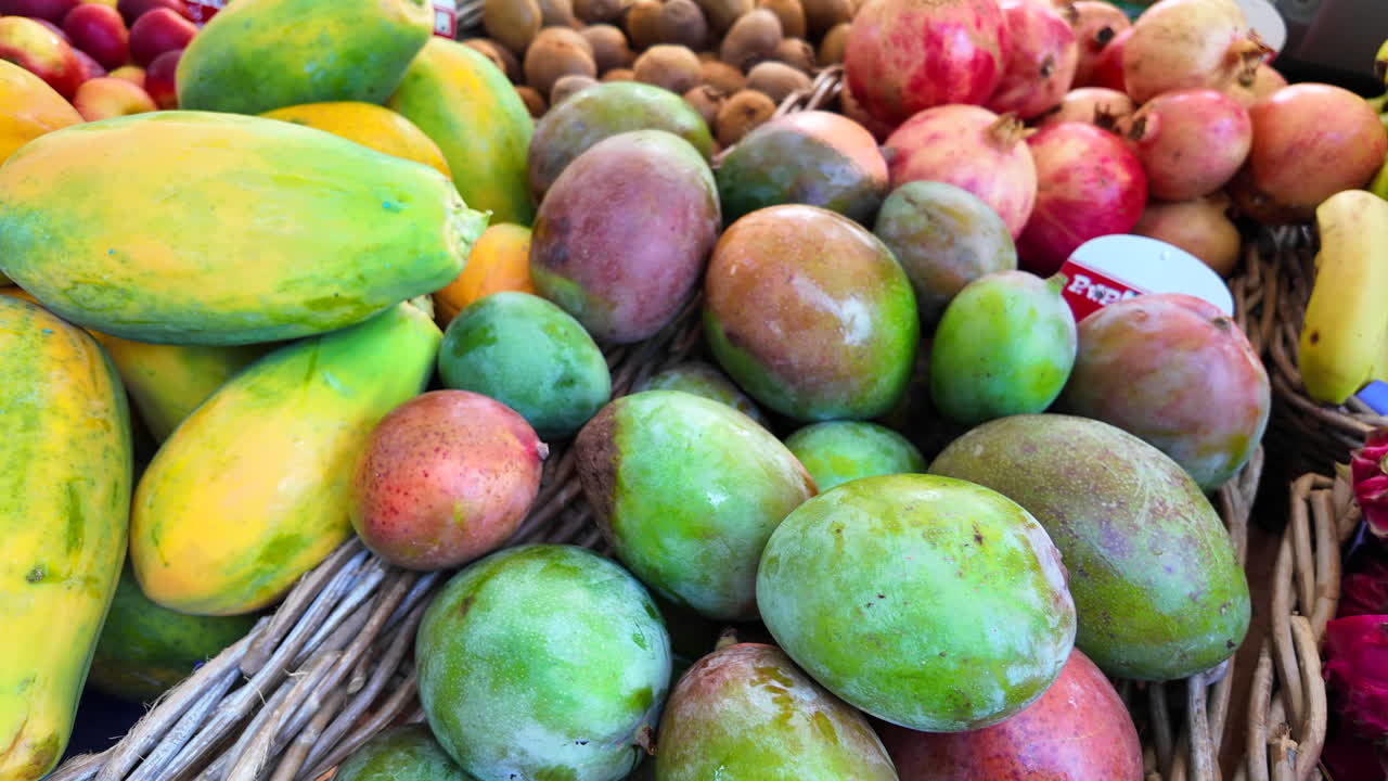 frutas exóticas para la venta en un mercado de agricultores orgánicos con frutas de dragón biológicas frescas, mango, papaya, granada, kiwi y plátano, tiro 4k