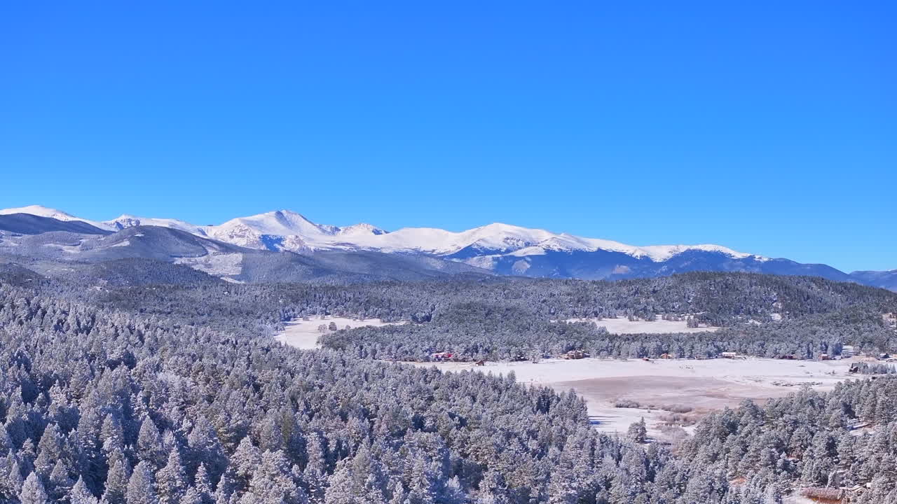 Christmas first snow Evergreen Three Sisters Front Range Denver Mount Blue Sky Evans aerial cinematic drone crisp freezing cold morning beautiful blue sky frosted pine trees zoomed upward pan motion