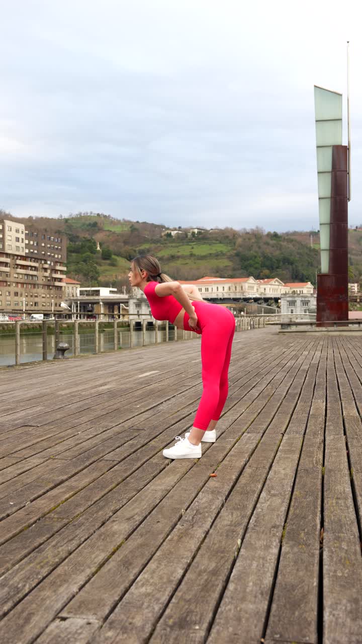 Woman in pink workout clothes exercising outdoors