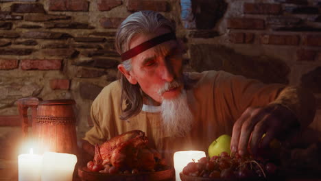 elderly lord eats meal and greets guest at medieval party. mature aristocrat sits at served dining table while unexpected visitor comes in. rich banquet