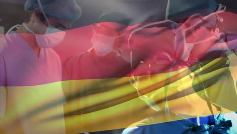 Animation-of-waving-germany-flag-against-team-of-diverse-surgeons-performing-operation-at-hospital